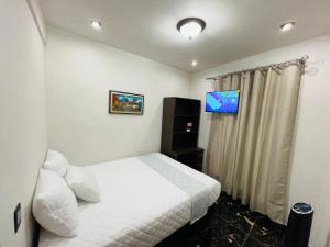 a hotel room with a bed and a television at casa Borde Del Lago1 in Panajachel