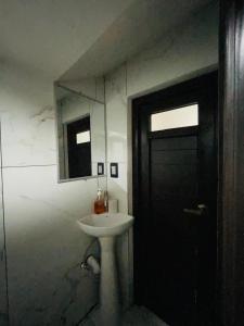 a bathroom with a sink and a black door at casa Borde Del Lago1 in Panajachel