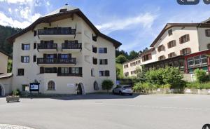 a white building with a car parked in front of it at Charming Studio - Ferienwohnung - Vulpera, Scuol in Scuol