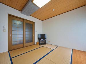 an empty room with a door and a television at Kamogawa Sunset Villa - 鴨川サンセットヴィラ in Kamogawa