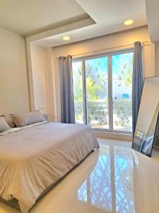a bedroom with a bed and a large window at Condo Azul in Cancún