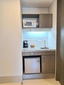 a kitchen with a sink and a microwave at Condo Azul in Cancún