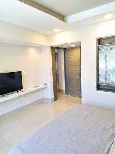 a bedroom with a bed and a flat screen tv at Condo Azul in Cancún