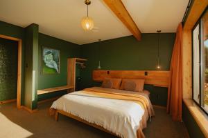 a bedroom with green walls and a bed in it at Surfwatch House in Kaikoura