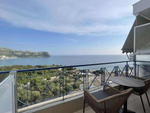 a balcony with a table and chairs and the ocean at Enopia Apartments Himara in Himare