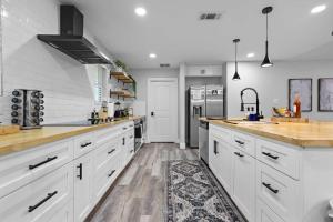 een keuken met witte kasten, een wastafel en een koelkast bij Dallas Family Fun Haus with Pool and Massive Game Room in Dallas