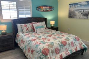 una camera da letto con un letto con un piumone floreale di Lulu's Crescent Cottages - Entire two unit complex a Sarasota Altre 37 foto