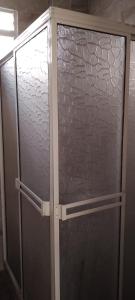 a glass shower door in a bathroom at Habitaciones cerca al aeropuerto& alojamiento &apartaestudio in Palmira