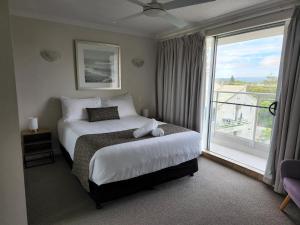 a bedroom with a bed and a large window at Pacific Surf Absolute Beachfront Apartments in Gold Coast +75 photos