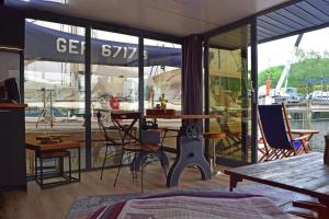 eine Terrasse auf einem Boot mit einem Tisch und Stühlen in der Unterkunft Houseboat Leni, Flensburg in Flensburg