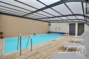 a large swimming pool with a ceiling at Ormeau in Erquy
