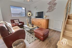 a living room with a couch and a television at Patelle in Erquy