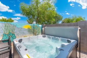 a hot tub in a backyard with a mural at Button Bungalow Spring Fun & Golfing Hot Tub BBQ in Mesa