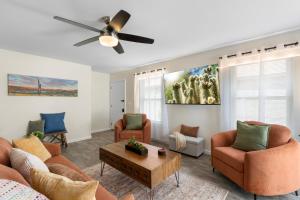 a living room with couches and a ceiling fan at Button Bungalow Spring Fun & Golfing Hot Tub BBQ in Mesa