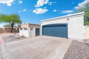 a garage with a large garage door on a house at Button Bungalow Spring Fun & Golfing Hot Tub BBQ in Mesa