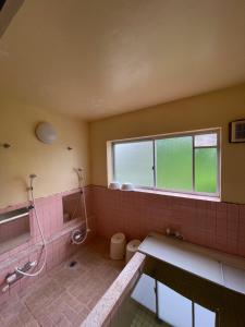 a bathroom with a sink and a toilet and a window at 夢冒険 in Myoko