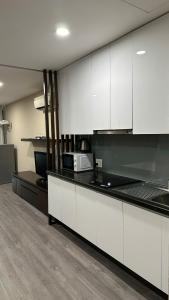 ホーチミン・シティにあるPNT Houseの白いキャビネットと電子レンジを備えたキッチン +14枚の写真