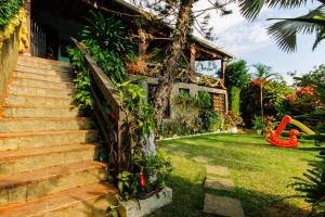 een huis met een tuin met een rode glijbaan bij Suítes Casa do Barão in Búzios
