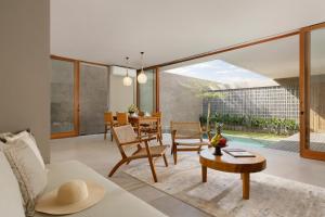 チャングーにあるPulang Villas Pererenan by Nakulaのテーブルと椅子のあるリビングルーム