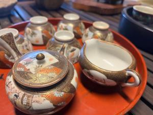a tray with a teapot and cups on a table at はたご屋ちゅうべ in Taki