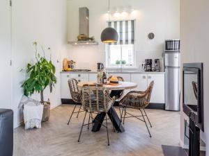Una cocina con una mesa y sillas en una habitación. en Bungalow near Dutch Coast & Forest, en Noordwijk