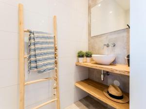 un baño con lavabo y espejo en Bungalow near Dutch Coast & Forest, en Noordwijk 4 fotos más