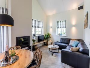 una sala de estar con un sofá y una mesa en Bungalow near Dutch Coast & Forest, en Noordwijk