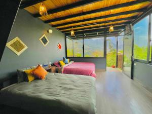 a bedroom with two beds and a large window at Bình An House in Sapa