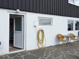 a hose attached to a building with a table and chairs at Central Trshavn Apartment in Tórshavn +4 photos