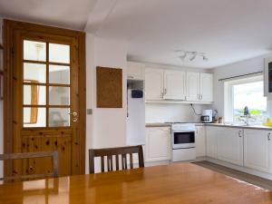 a kitchen with white cabinets and a table and a window at Central Trshavn Apartment in Tórshavn