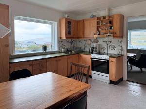 a kitchen with wooden cabinets and a table and a window at Lovely 5-bedroom House With Cozy Interiors in Trongisvágur