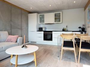 a kitchen and living room with a couch and a table at Modern And Cozy Apartment in Tórshavn