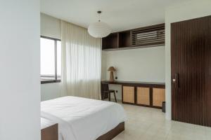 a bedroom with a bed and a desk in it at Jena Island Villa in Cemagi +13 photos
