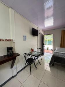 a room with a table and a bed and a bedroom at Cabinas Caribe Azul in Cocles