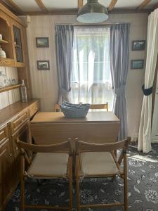 a kitchen with a table and two chairs and a window at 77 Glenfinart Caravan Park in Dunoon