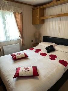 a bedroom with a bed with red roses on it at 77 Glenfinart Caravan Park in Dunoon