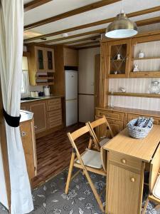 a kitchen with a table and a chair in it at 77 Glenfinart Caravan Park in Dunoon
