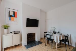 a dining room with a table and chairs and a tv at Urban Oasis Serviced Suite - Families, remote work, corporate, contractors in Spon End