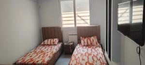 two beds sitting next to each other in a room at Holiday Apartment 3 in Jijel