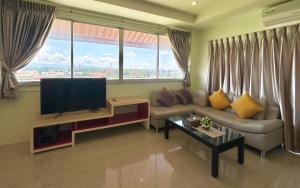 a living room with a couch and a flat screen tv at A.K. Terrace Hotel in Sara Buri