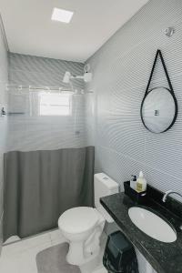a bathroom with a toilet and a sink and a shower at Apartamento inteiro Pé No Forró in Petrolina