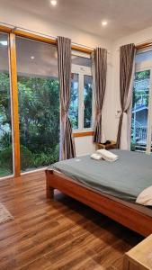 une chambre avec un lit dans une pièce avec des fenêtres dans l'établissement 3 Tầng Mây Homestay & Coffee, à Xuân Thọ 10 autres photos