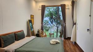 une chambre avec un lit et une grande fenêtre dans l'établissement 3 Tầng Mây Homestay & Coffee, à Xuân Thọ