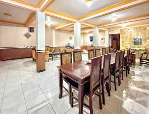 a dining room with a wooden table and chairs at RedDoorz at Hotel Huni Raya Bromo in Pasuruan