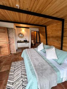 a large bed in a room with a wooden ceiling at Glamping Pozo Azul, Villa de Leyva in Villa de Leyva