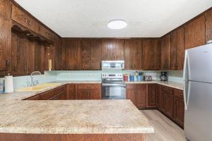 a kitchen with wooden cabinets and a white refrigerator at Relaxing River Cabin!  +15 photos