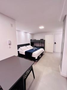 a bedroom with a bed and a table in it at Loft pertinho da Vila Germânica com excelente localização in Blumenau +36 photos