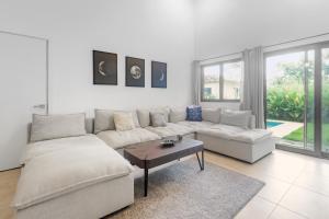 a white living room with a couch and a table at Casa Ola - Tropical Beachside Escape in Playa Venao