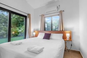 a bedroom with a white bed and a large window at Casa Ola - Tropical Beachside Escape in Playa Venao