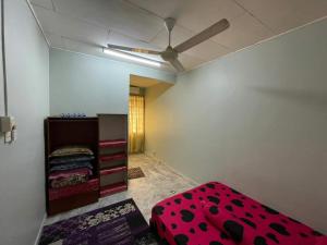 a bedroom with a red bed and a ceiling fan at DM Homestay in Semenyih